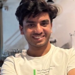 Kaushik, smiling, in a café